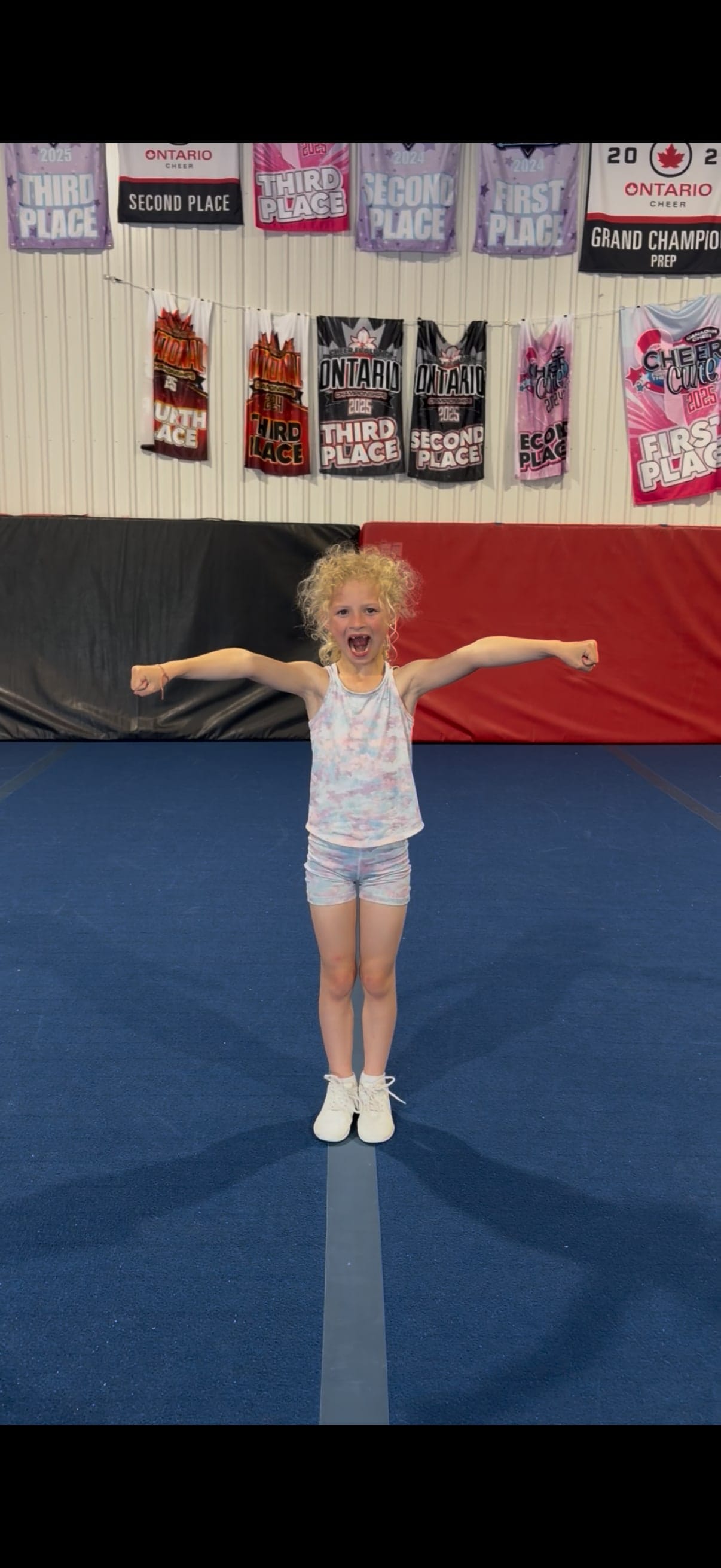 A young CheerCore Jags athlete holding a strong motion in the gym