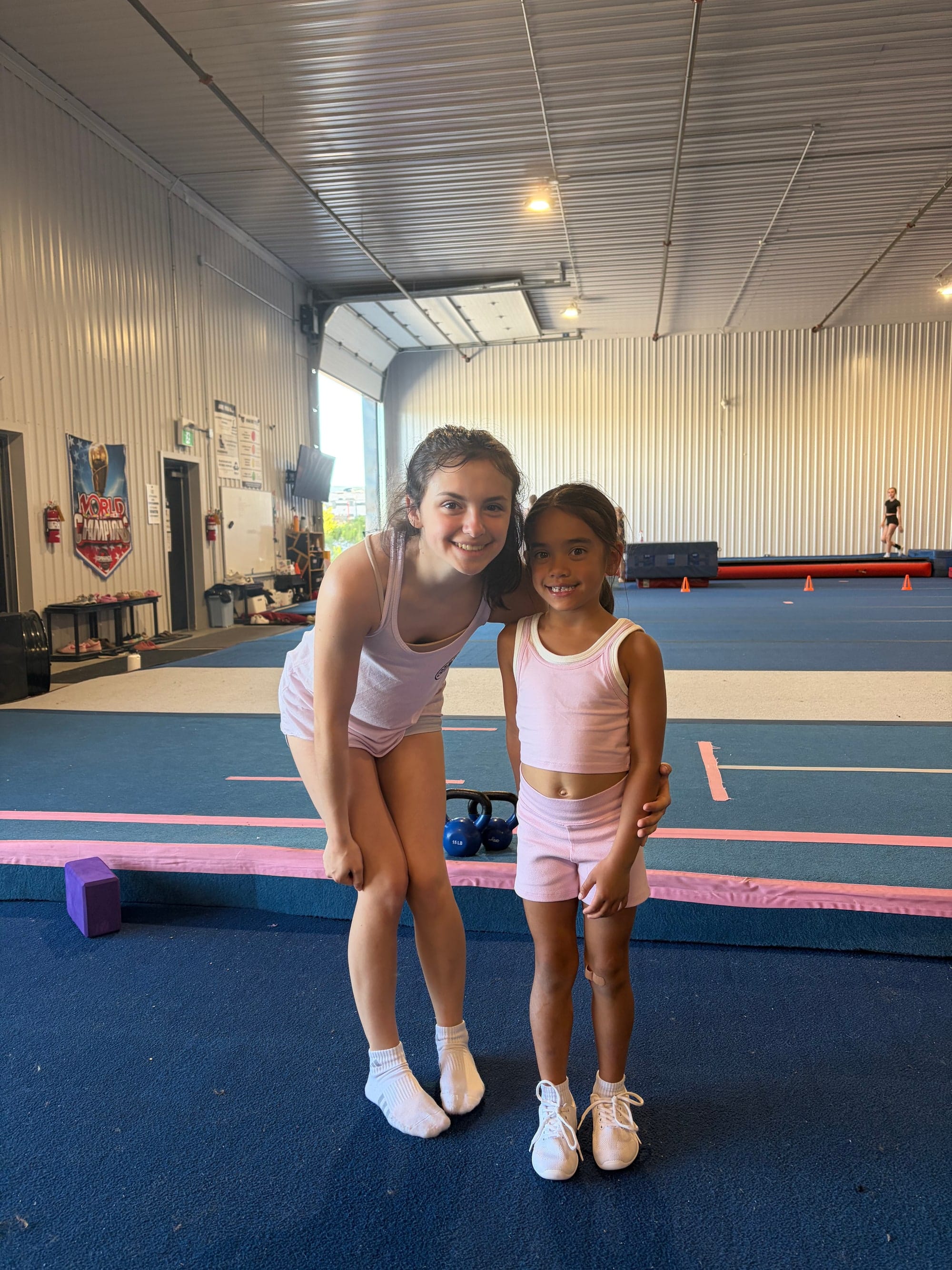 A CheerCore Jags coach with a young athlete on the training floor