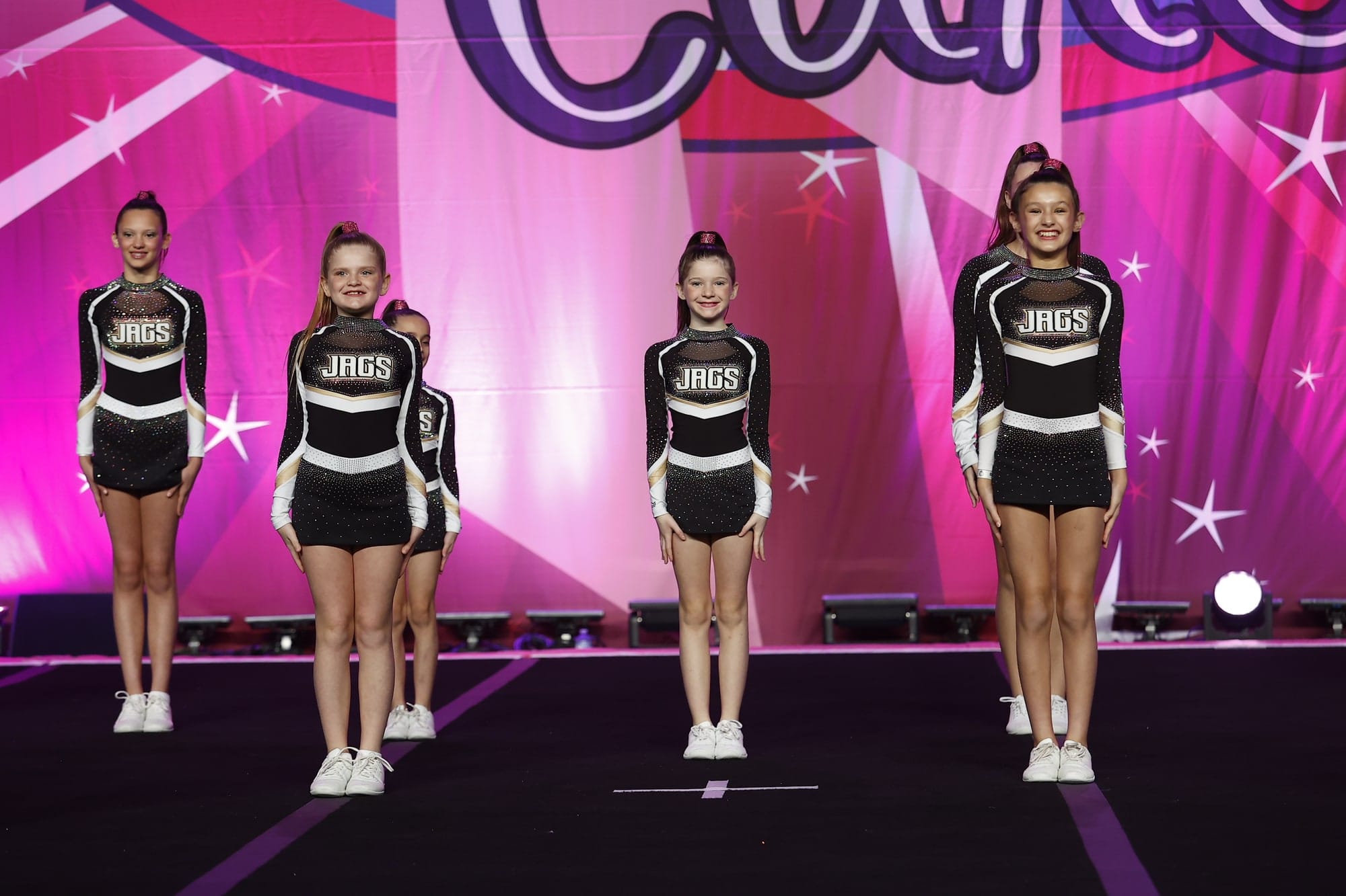 Four Prep Cheer athletes standing ready at the start of their routine
