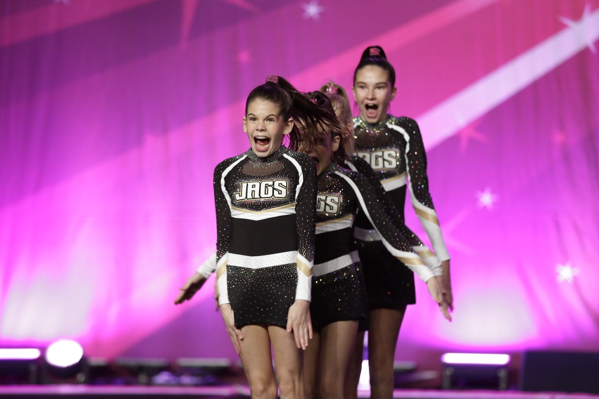 Three Prep Cheer athletes cheering at the end of their routine