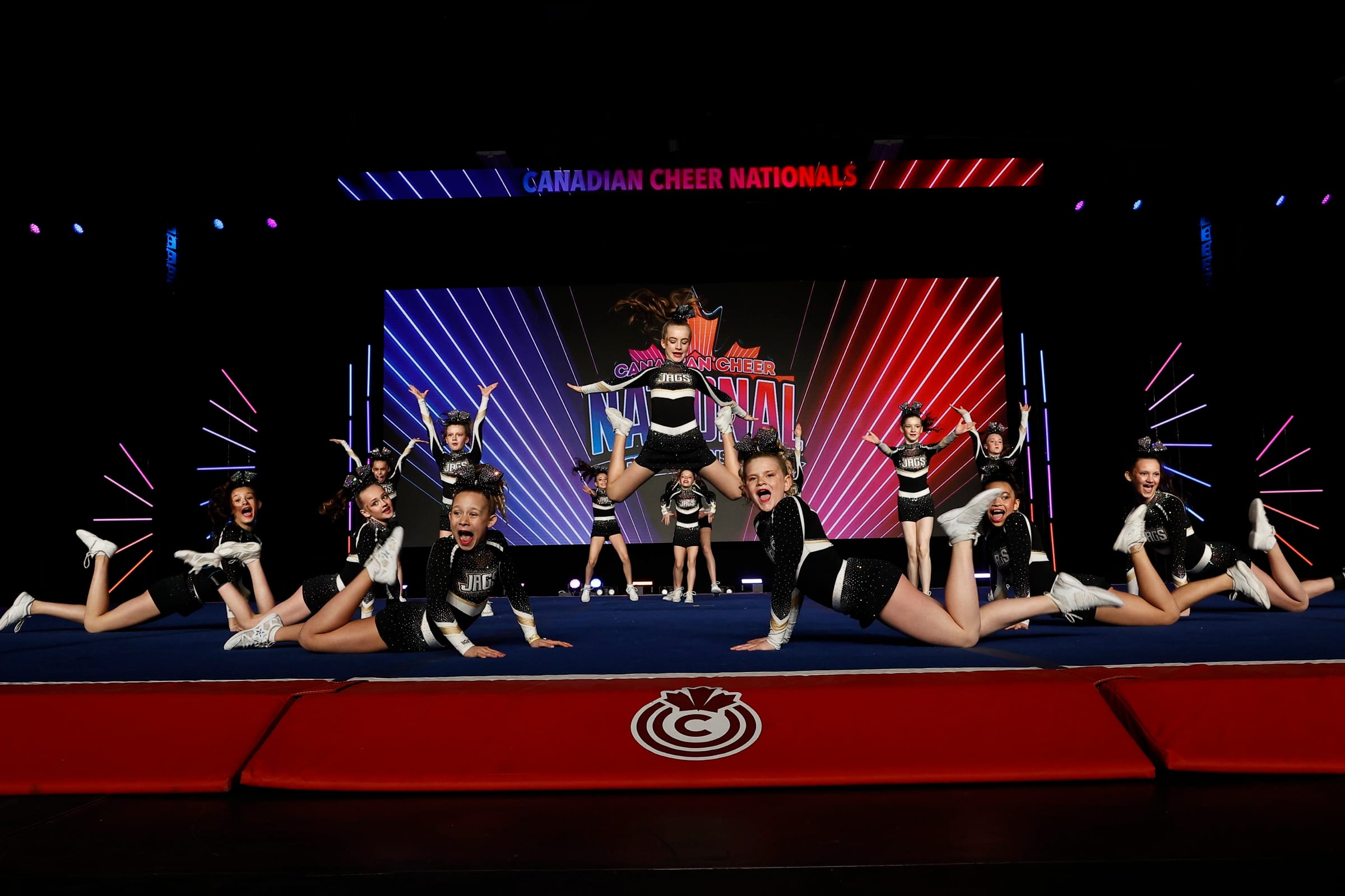 CheerCore Jags athletes hitting splits and a jump on the competition floor
