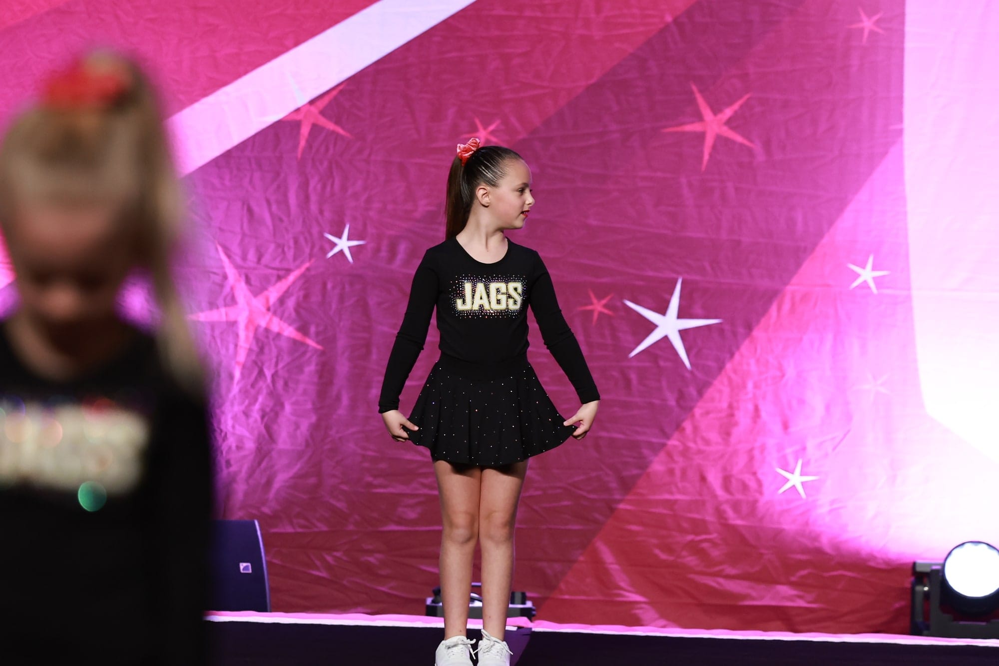 A Novice Cheer athlete performing on stage at Cheer for the Cure