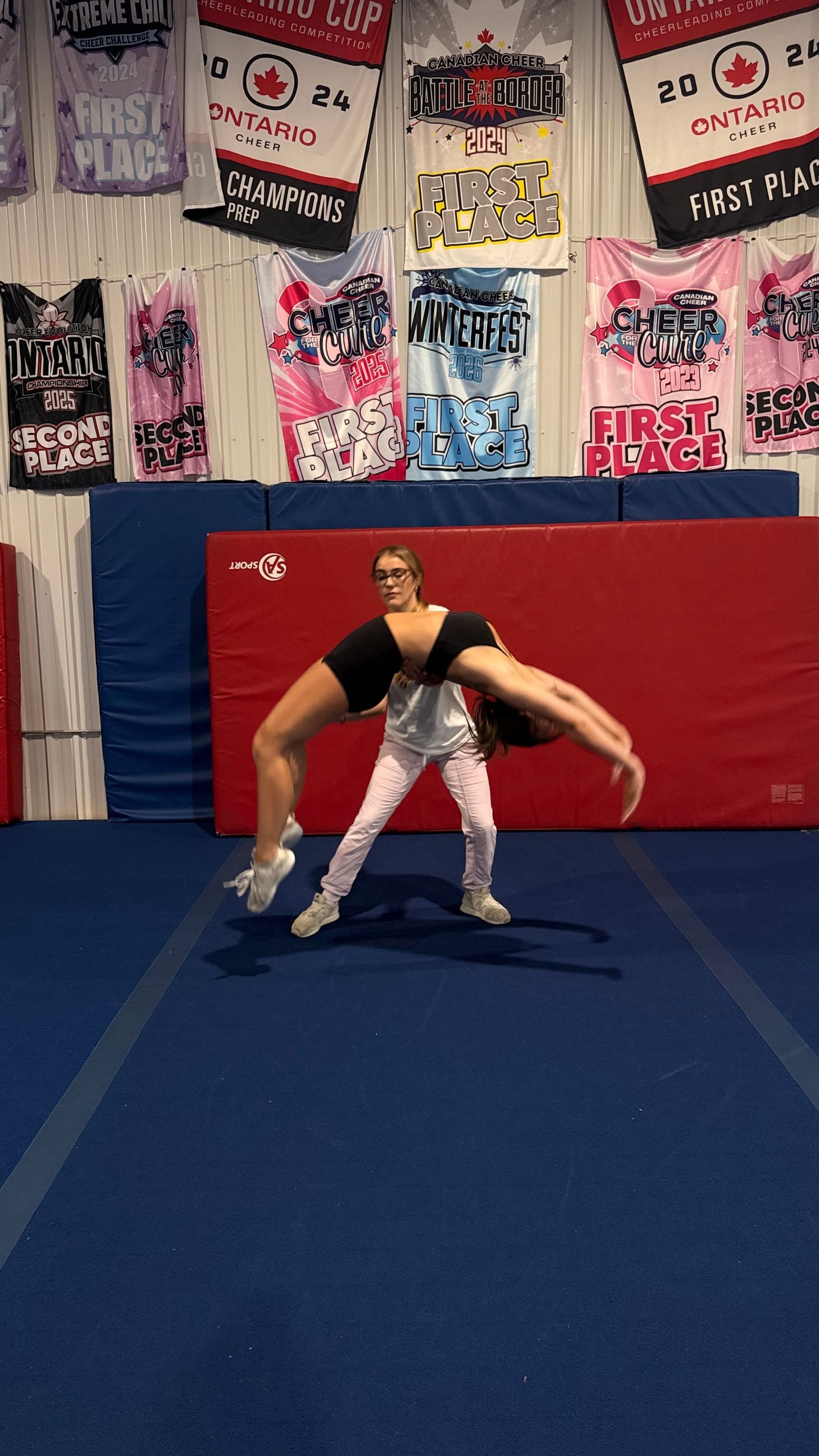 A CheerCore Jags coach spotting an athlete through a back walkover